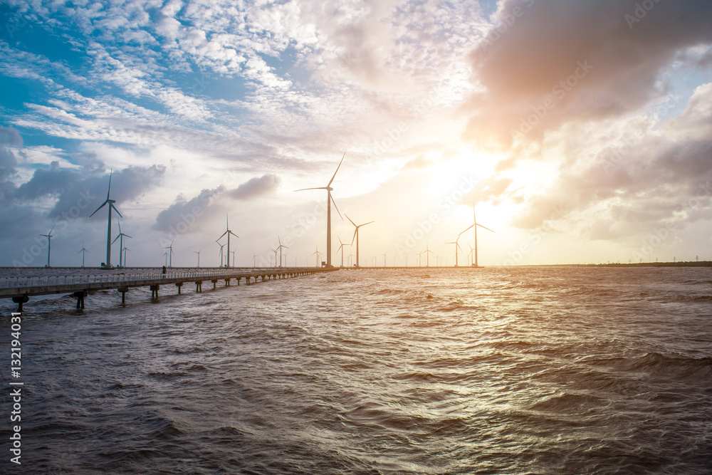 Wind turbines at sunset. Ecology wind against cloudy sky backgro