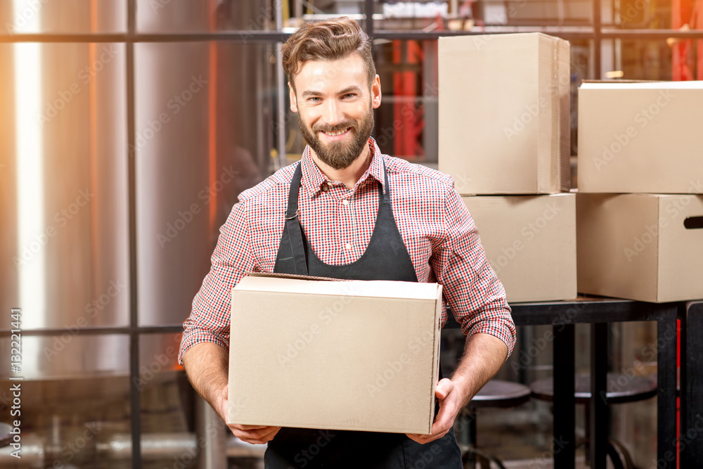 Portrait of professional courier with boxes delivering packages at the manufacturing.