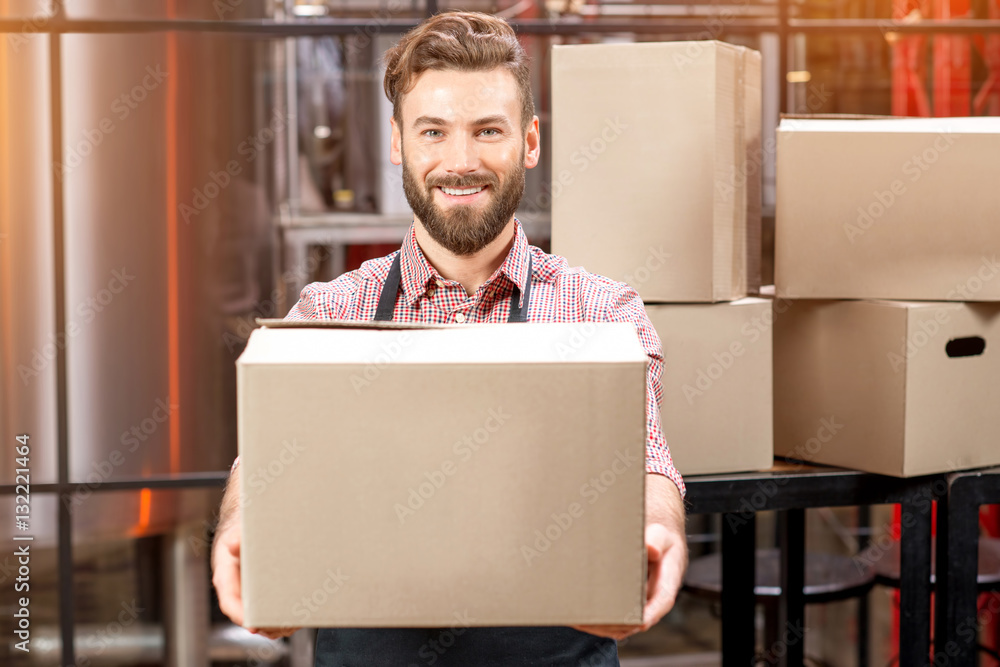 Portrait of professional courier with boxes delivering packages at the manufacturing.