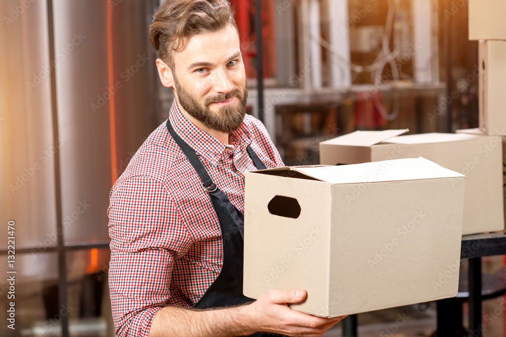 Portrait of professional courier with boxes delivering packages at the manufacturing.