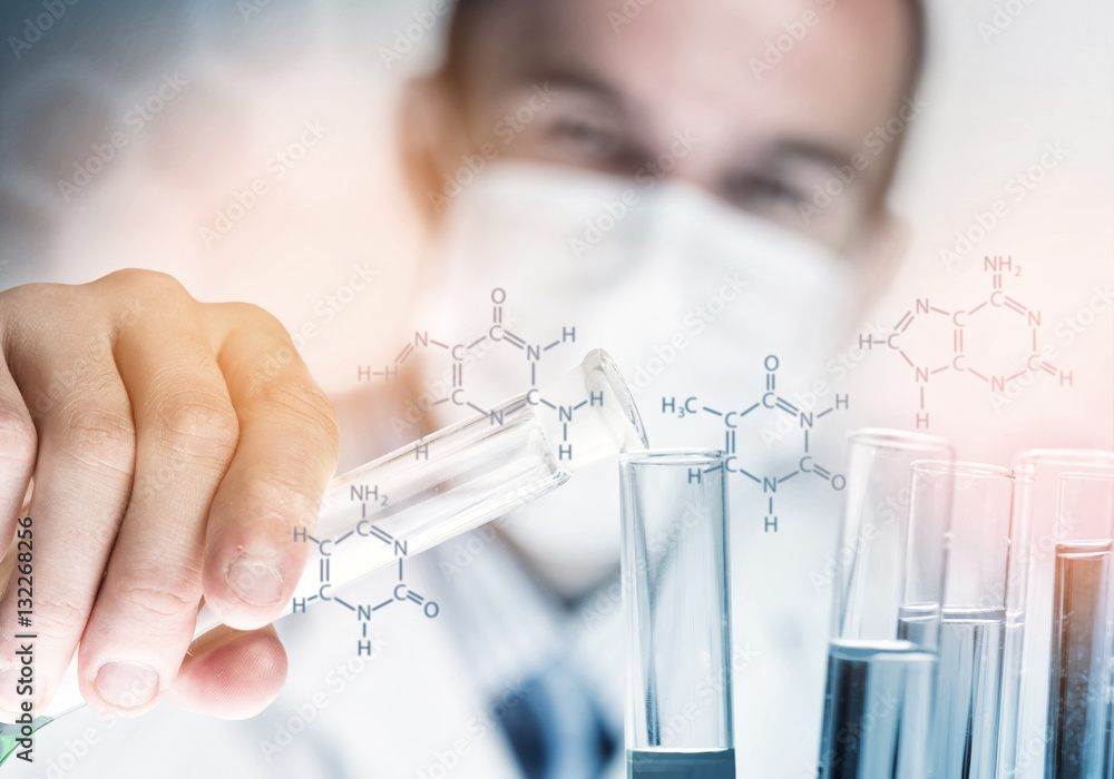 Portrait of concentrated male scientist working with reagents in laboratory