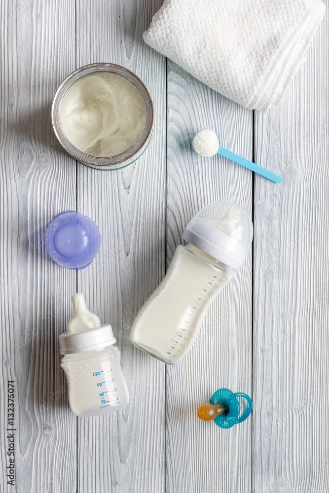 preparation of mixture baby feeding on wooden background top view