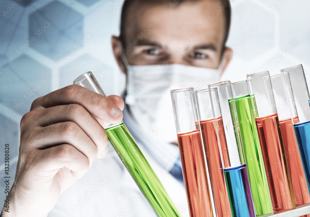 Portrait of concentrated male scientist working with reagents in laboratory