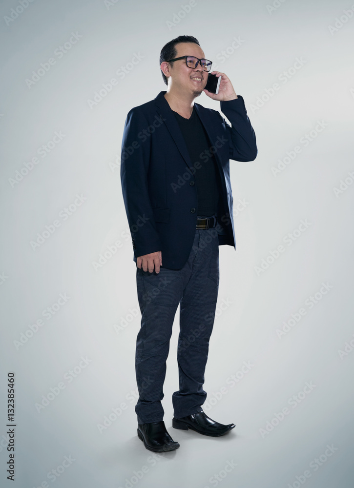 Happy smiling businessman wearing black suit and using modern smartphone