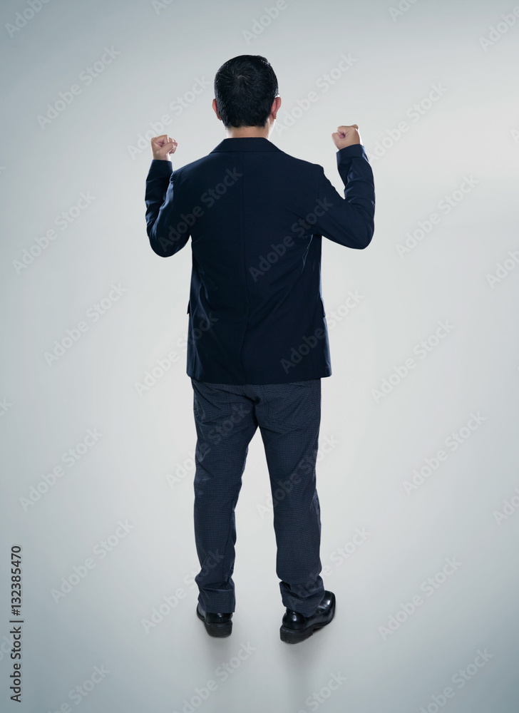 Back view of excited businessman  with arms up