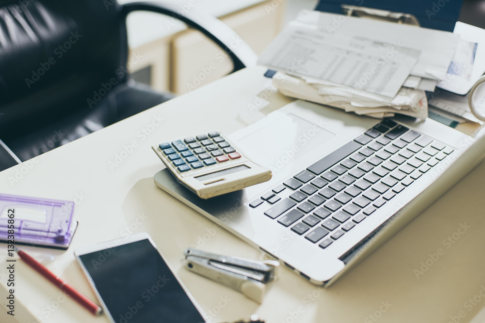 Calculator, documents and laptop on the table of business person