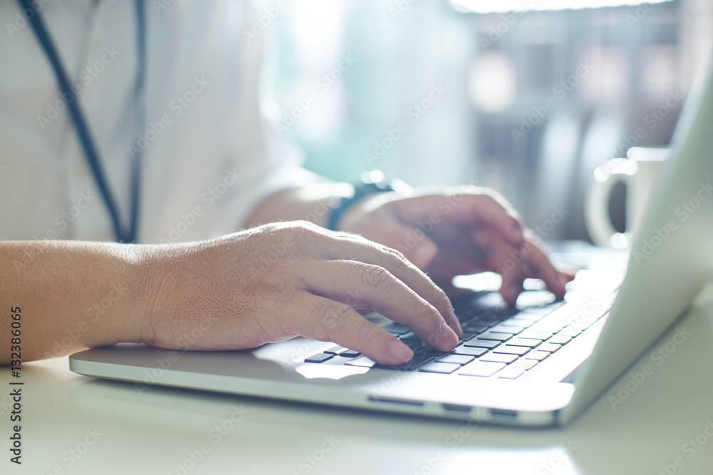 Businessman using laptop with tablet and pen on white table in office with a cup of coffee,close up 