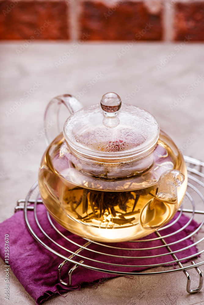 Glass teapot with tea on cooling rack. Front view.