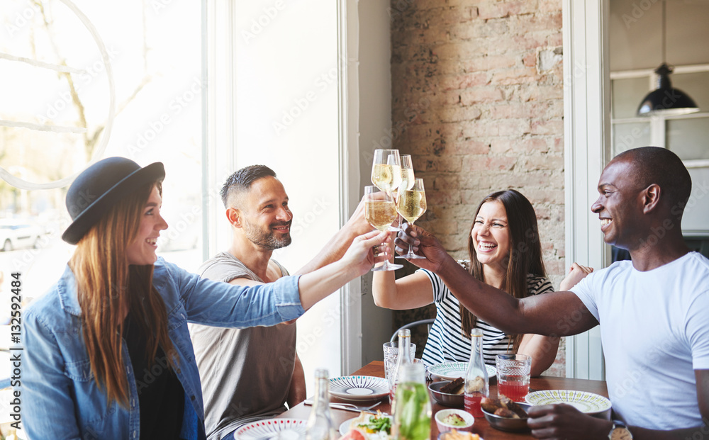 Group of young adults drinking together at table