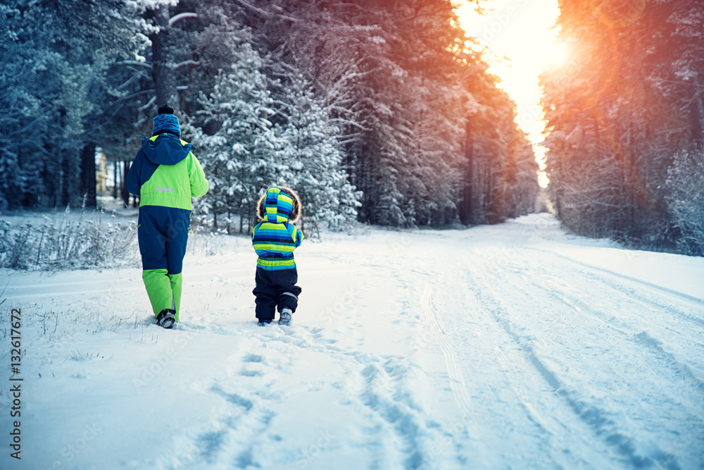 Boy in knitted hat, gloves and scarf outdoors at snowfall