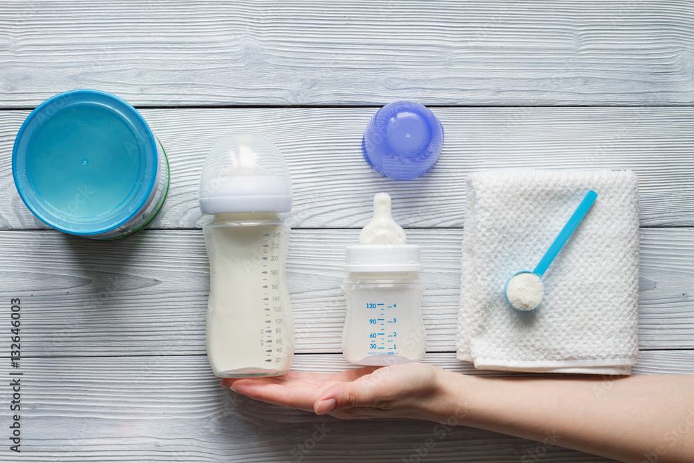 preparation of mixture baby feeding on wooden background top view