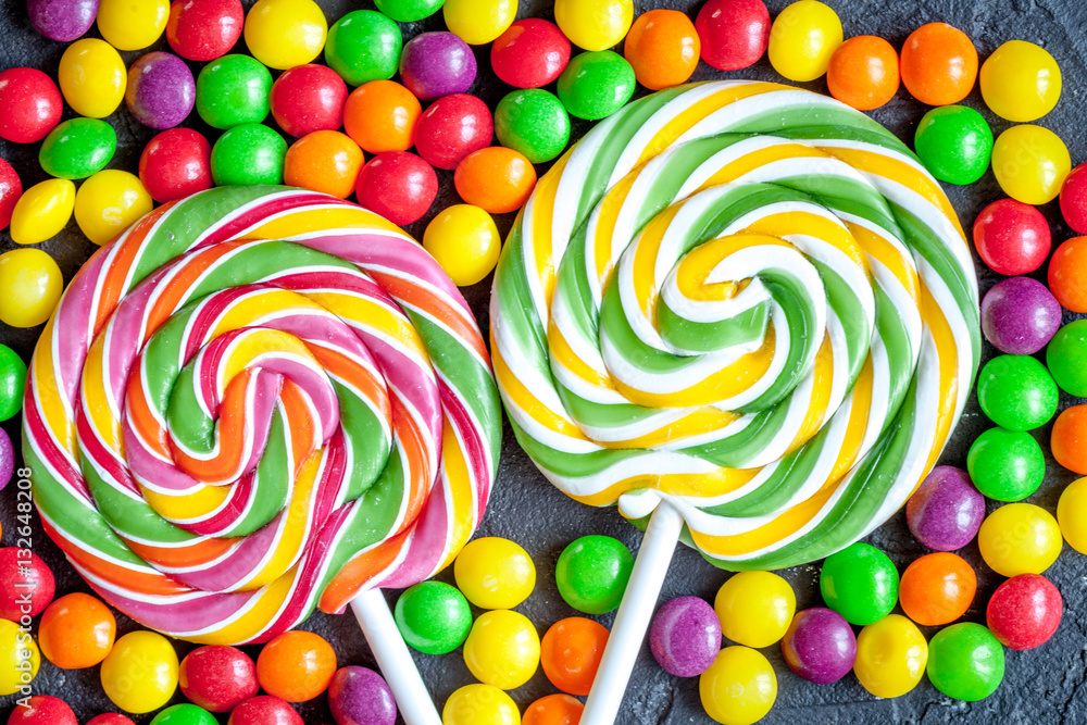 sweets and sugar candies on dark background top view