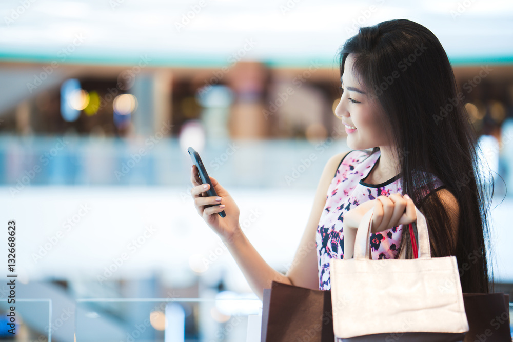 Asian women The purchasing power of the mall happy .Her phone sh