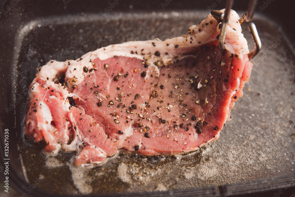 Beef steaks are fried in a pan.