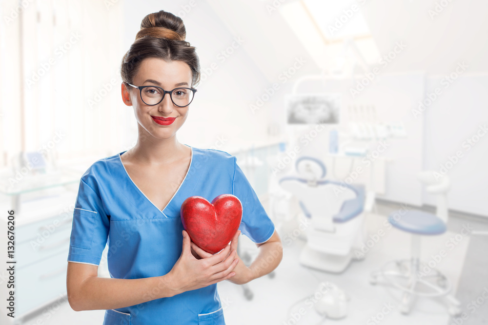 Portrait of female doctor with red heart in the dental office