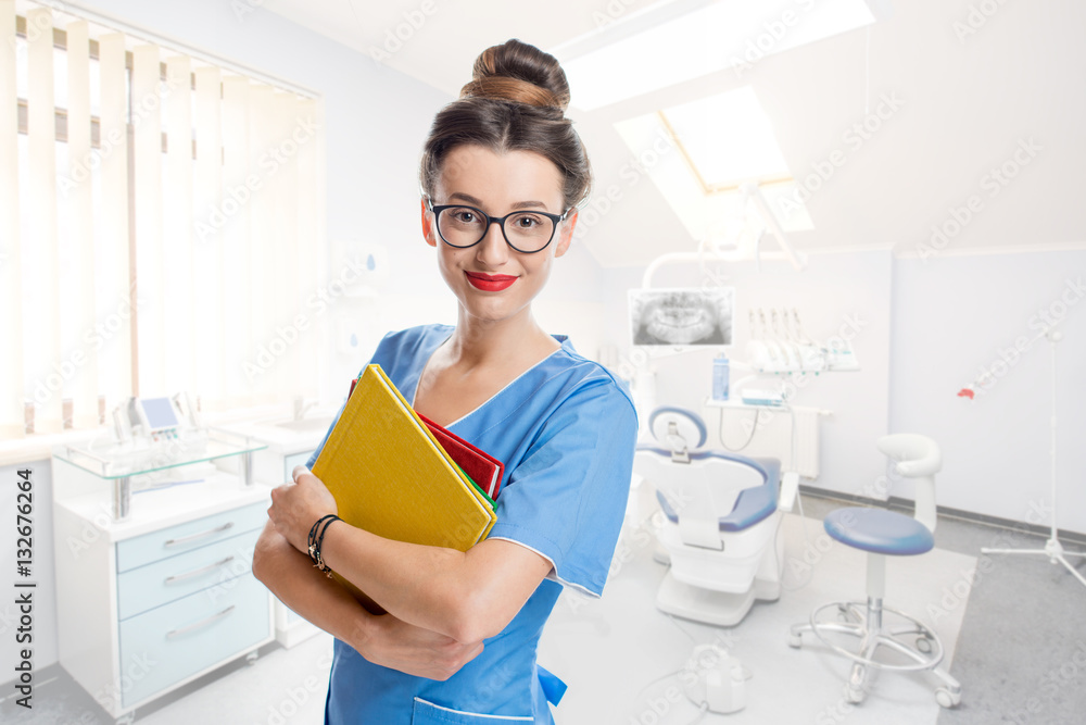 Portrait of young student of dentistry with books in the dental office