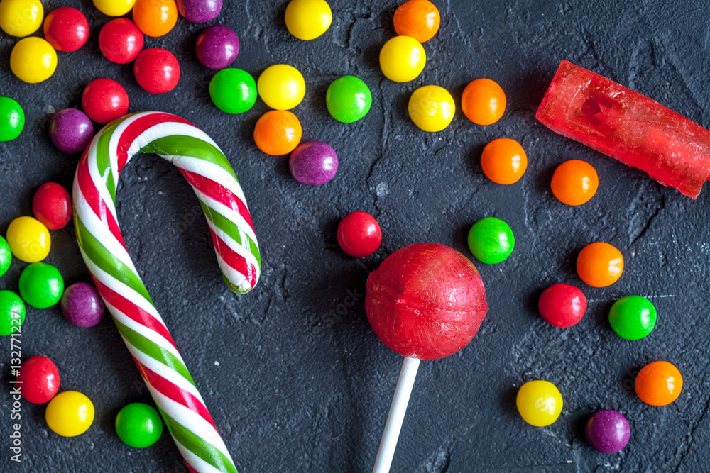 sweets and sugar candies on dark background top view