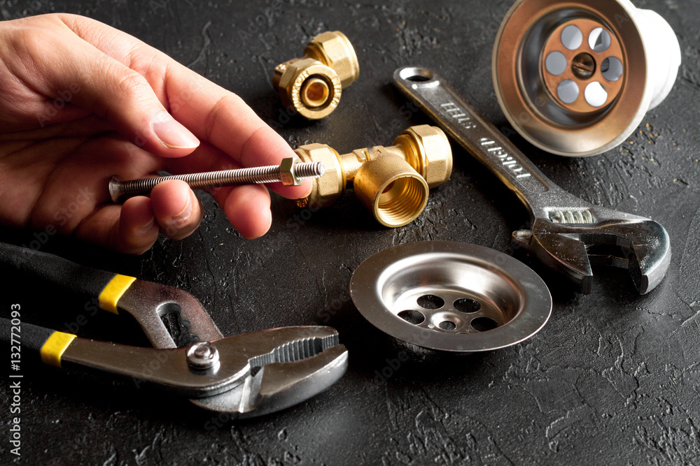 concept plumbing tools on dark background