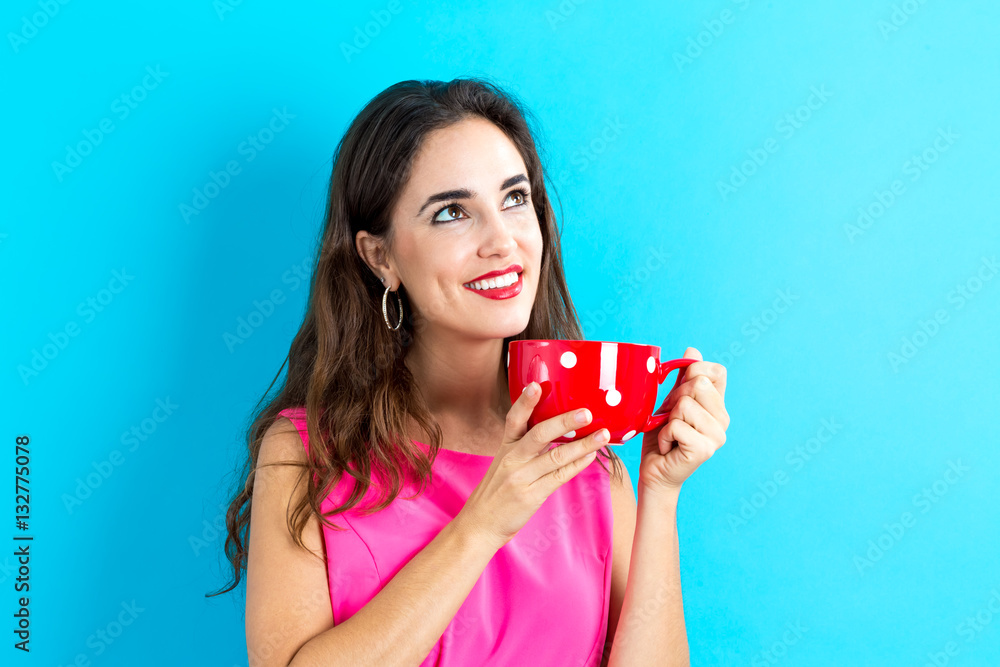 Happy young woman drinking coffee