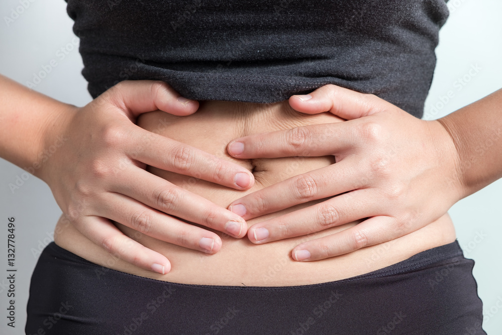 Pregnancy or diet concept, female hands protecting the stomach on white background.