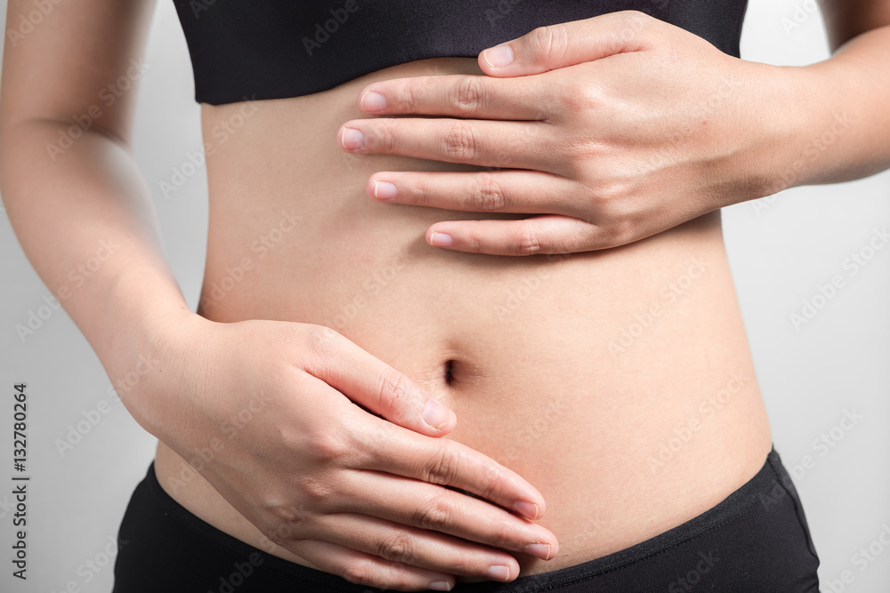 Pregnancy or diet concept, female hands protecting the stomach on white background.