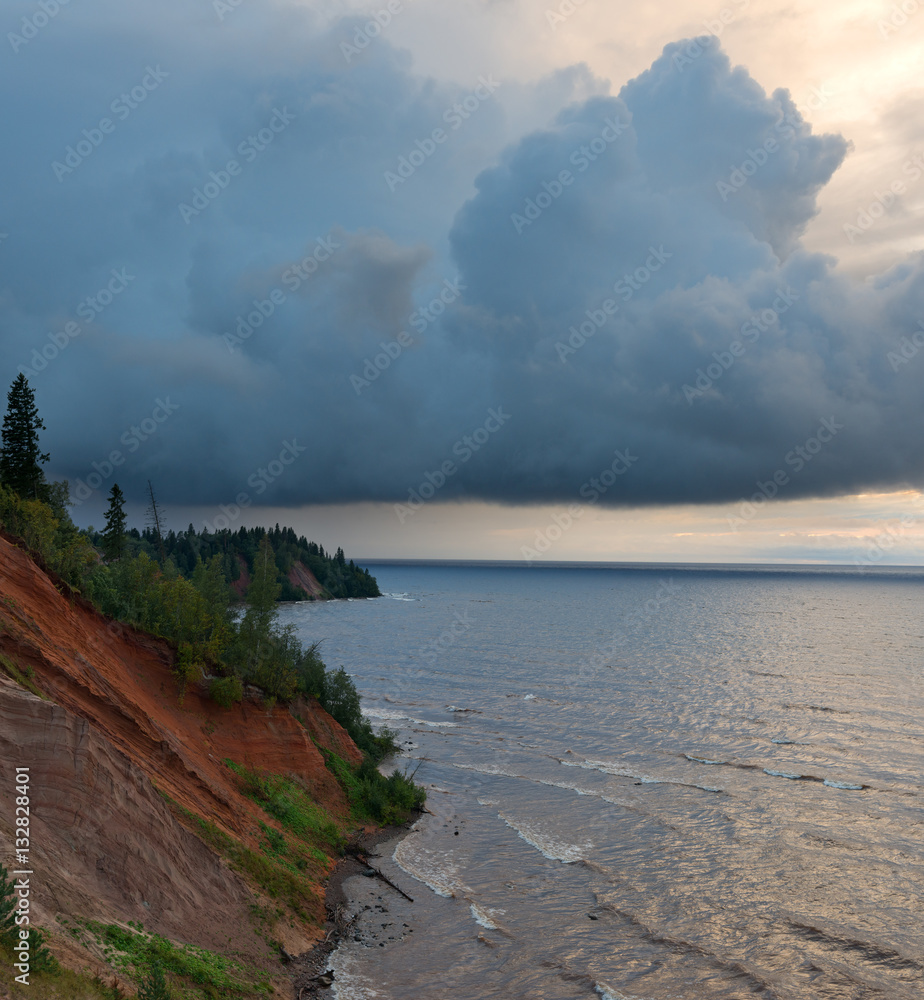 Majestic landscape with storm on the lake and huge thundercloud.