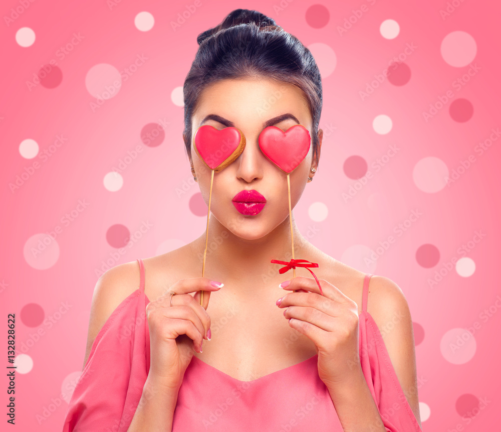 Valentines Day. Beauty joyful young fashion model girl with Valentine Heart shaped cookies in her ha