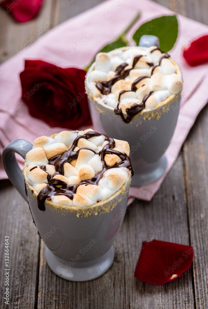 Smores drink. Two mugs of hot chocolate with marshmallows on a wooden table. Cocoa. Rose petals. Va