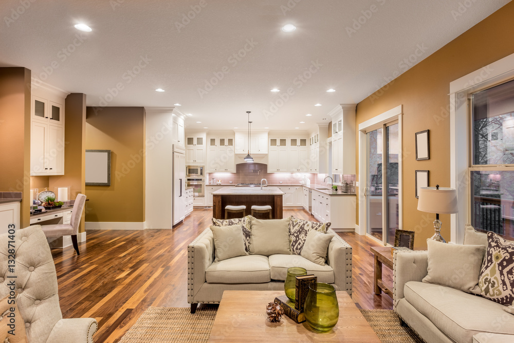 Beautiful living room interior with hardwood floors and kitchen view in new luxury home