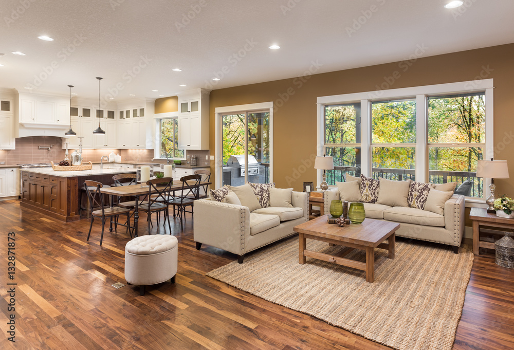 Beautiful living room interior with hardwood floors and view of kitchen in new luxury home