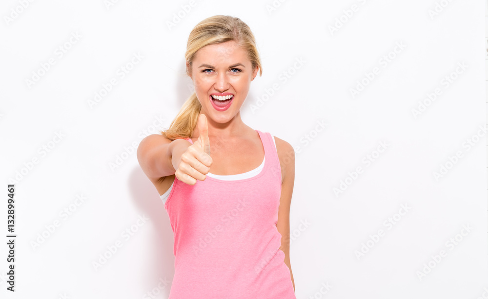 Happy young woman giving a thumbs up