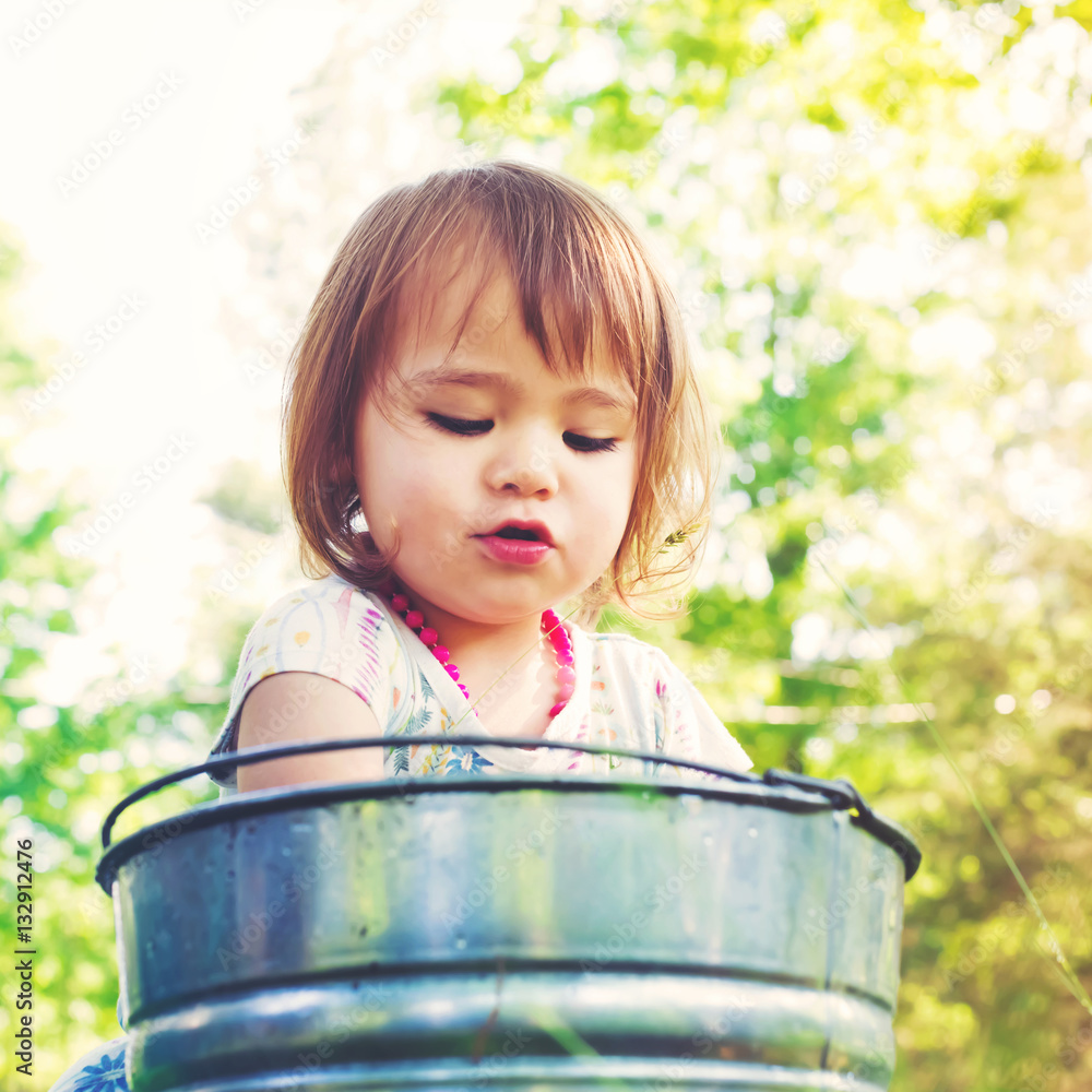 Happy toddler girl playing outside on a summer day