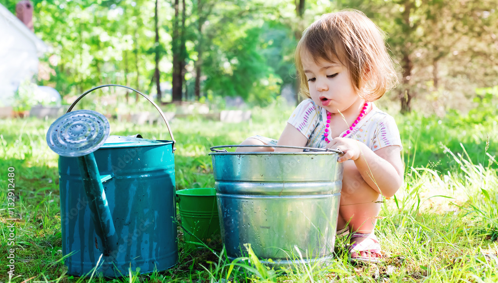 Happy toddler girl playing outside on a summer day