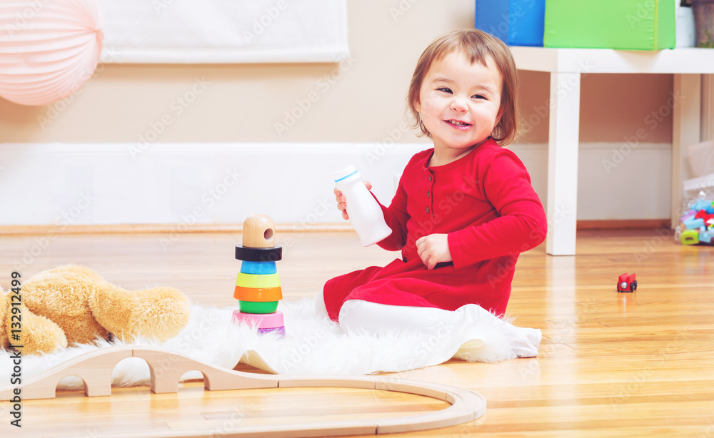 Happy toddler girl playing with her teddy bear