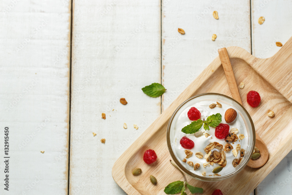 Homemade yogurt or sour cream in a glass on the white wooden tab