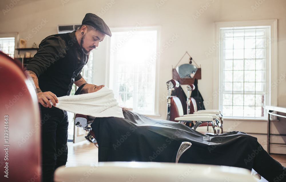 Hairdresser taking care of clients face in salon