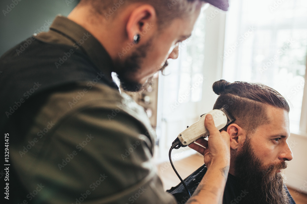 Hairdresser cutting hair of customer at salon