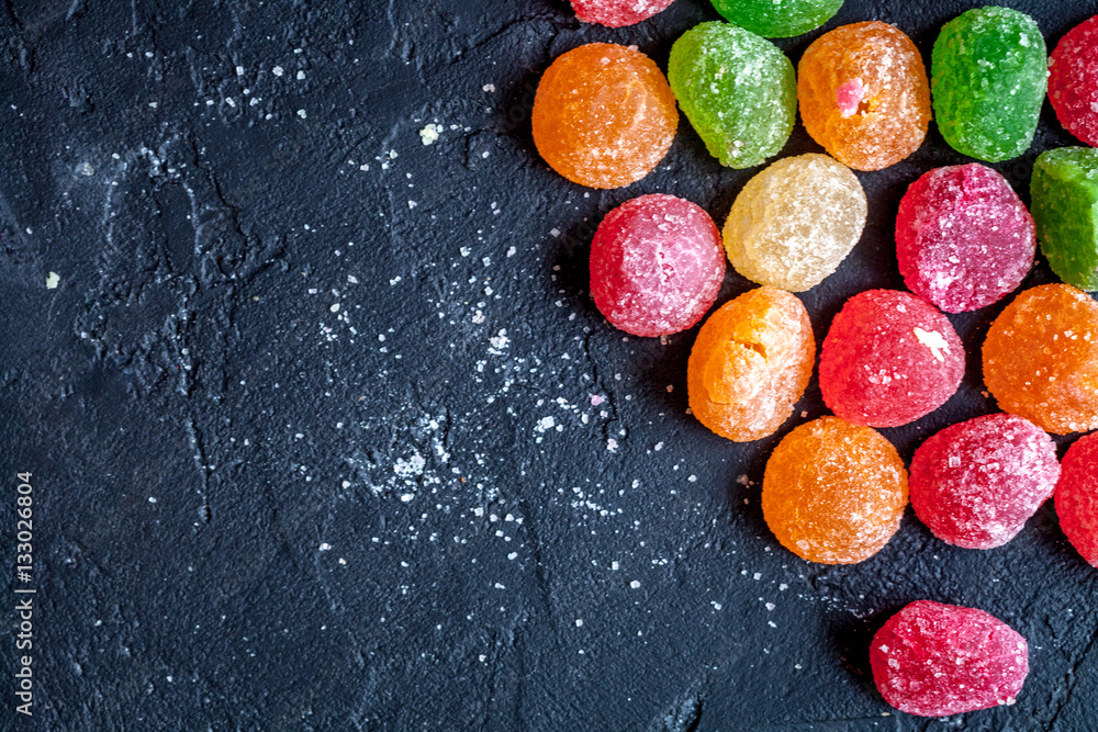 sweets and sugar candies on dark background top view