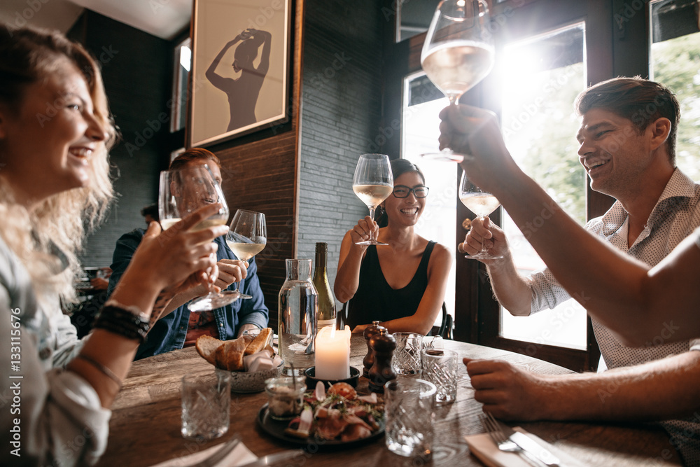 Group of friends making a toast at restaurant