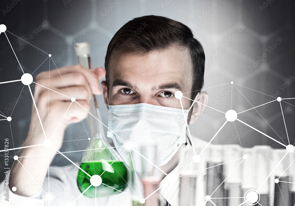 Portrait of concentrated male scientist working with reagents in laboratory