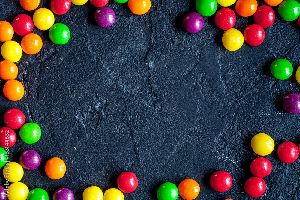 sweets and sugar candies on dark background top view