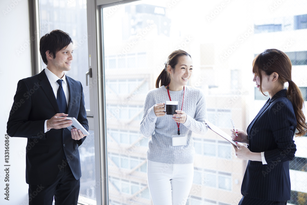 Young businessmen are talking on the window at the office