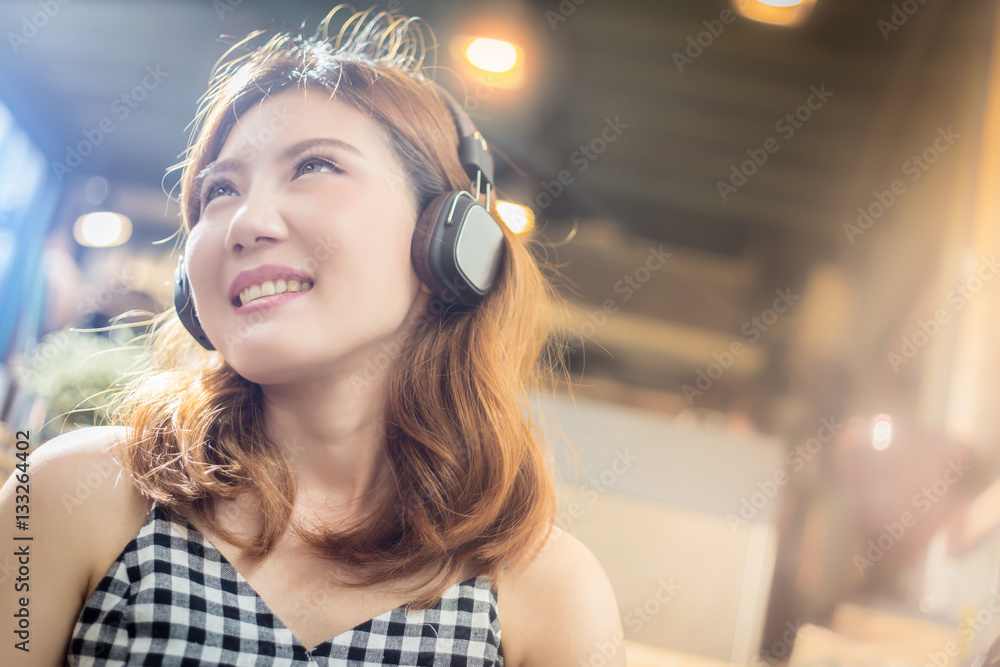 beautiful young asian woman listening to music with headphones