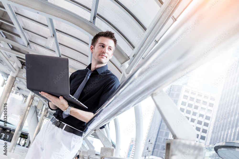 Caucasian businessman use of the notebook computer at outdoor