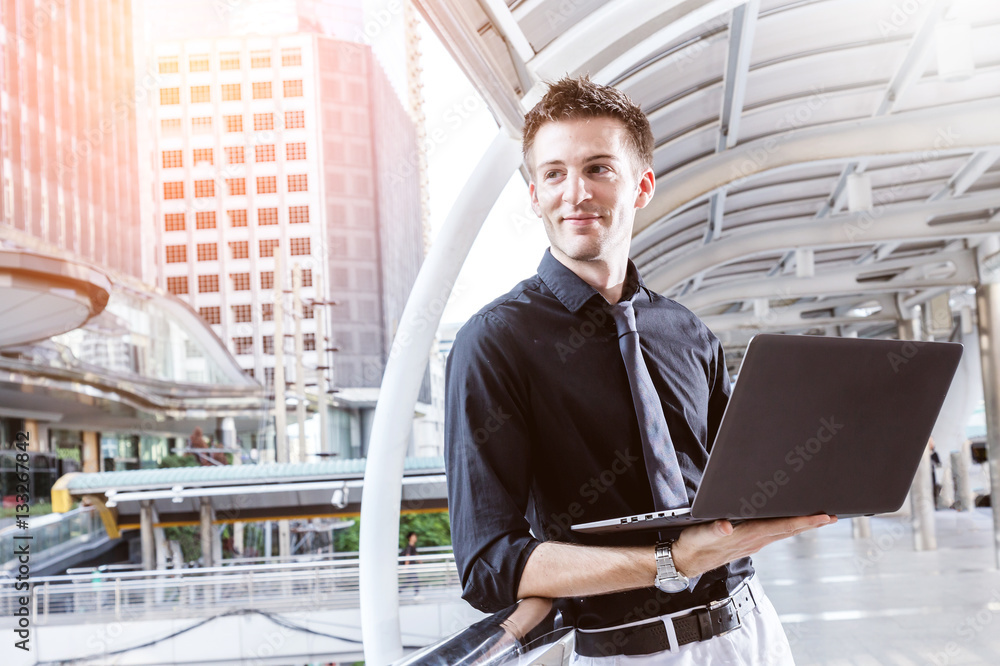 Caucasian businessman use of the notebook computer at outdoor