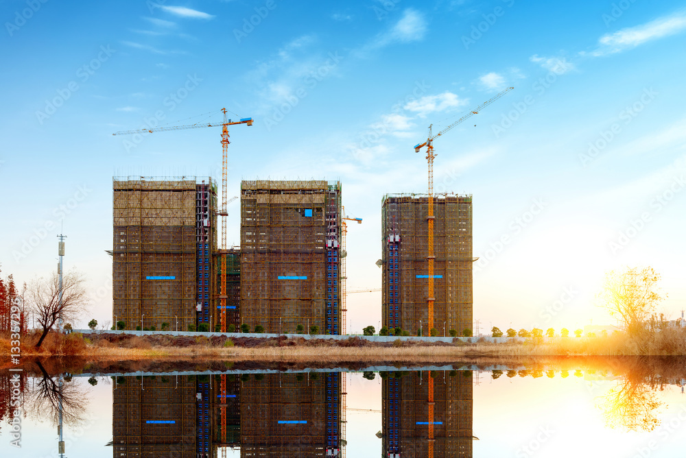 Construction site, workers and cranes.