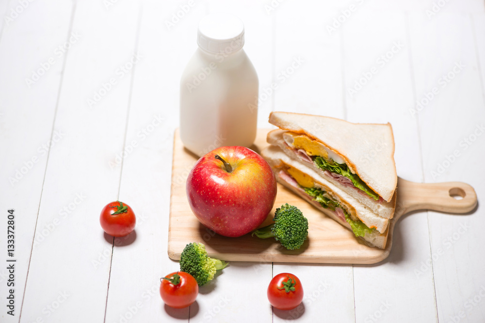 Lunch meal with milk, orange juice and sandwiches.