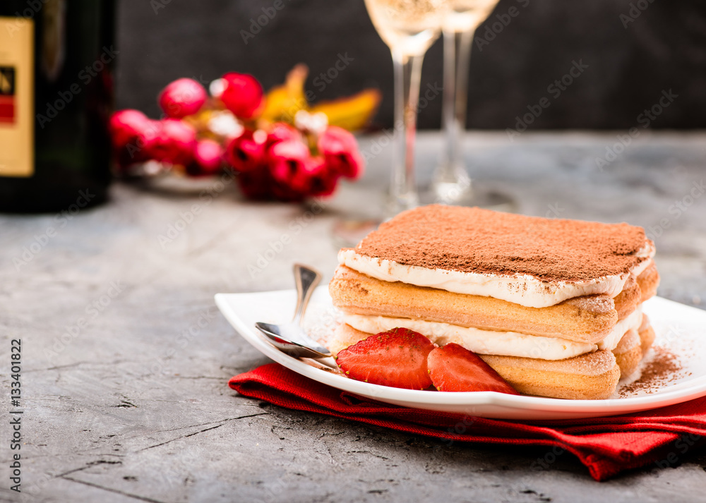 Tiramisu with strawberry and glasses of champagne on the table. Valentines concept.