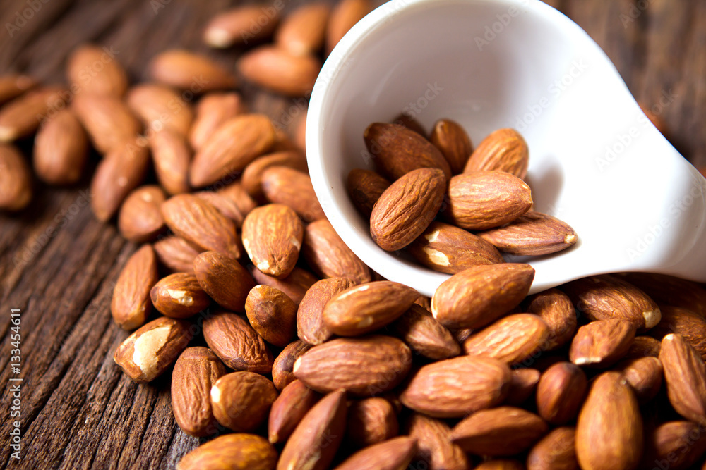 close up Peeled almonds nut  in small white cup on 