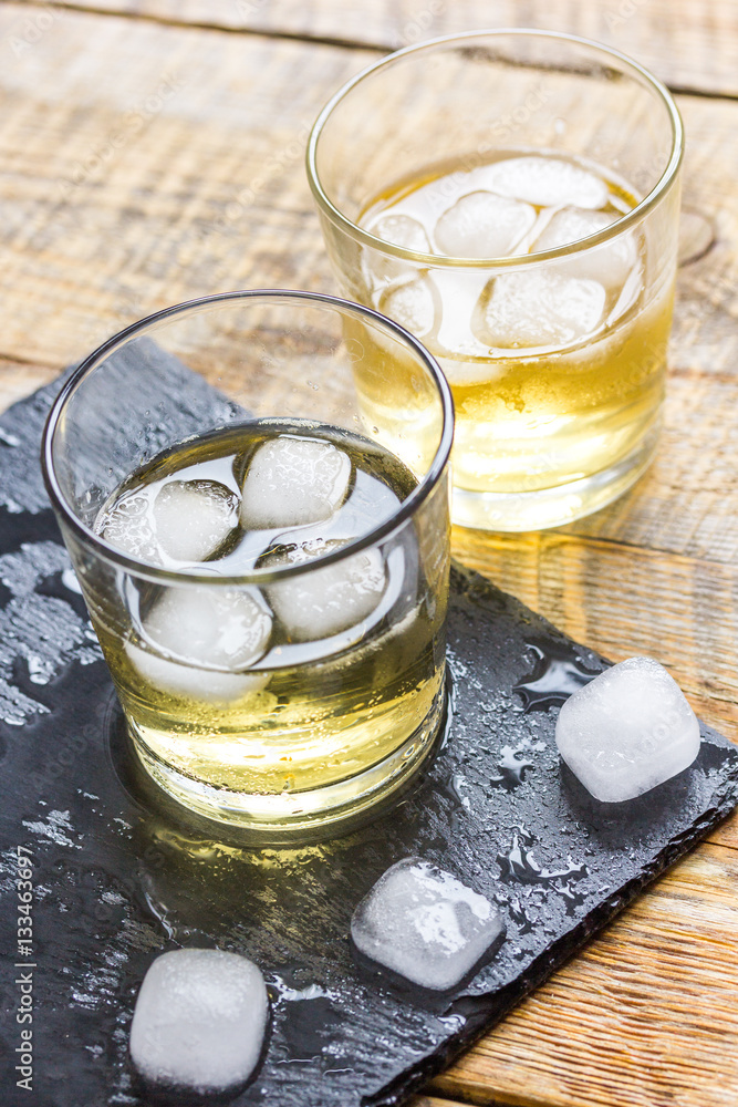 glass of whiskey on wooden background